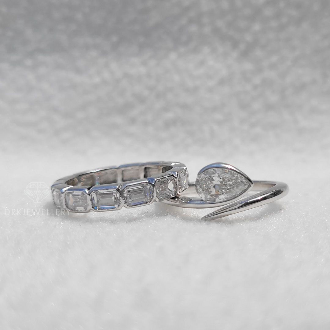 Bezel Set Pear Cut Lab Grown Diamond Ring With East West Emerald Band