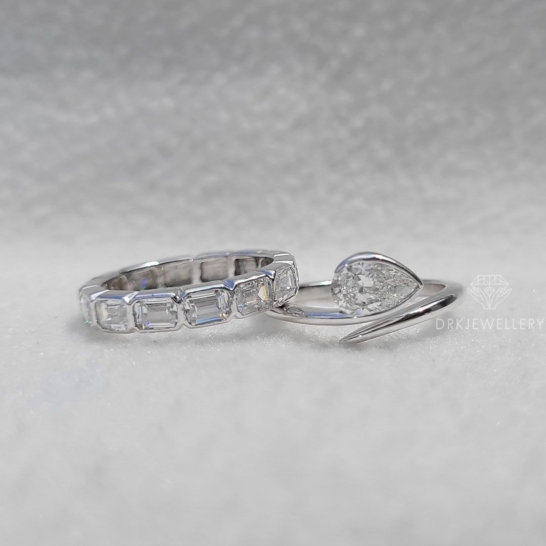 Bezel Set Pear Cut Lab Grown Diamond Ring With East West Emerald Band